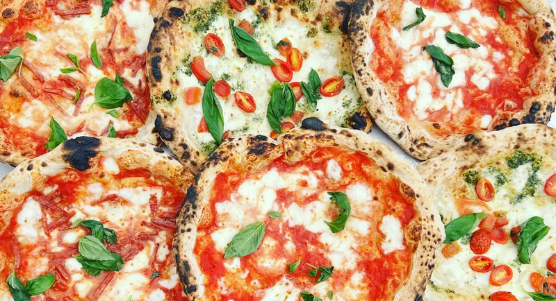 Margherita and pesto Neapolitan pizzas seen from above