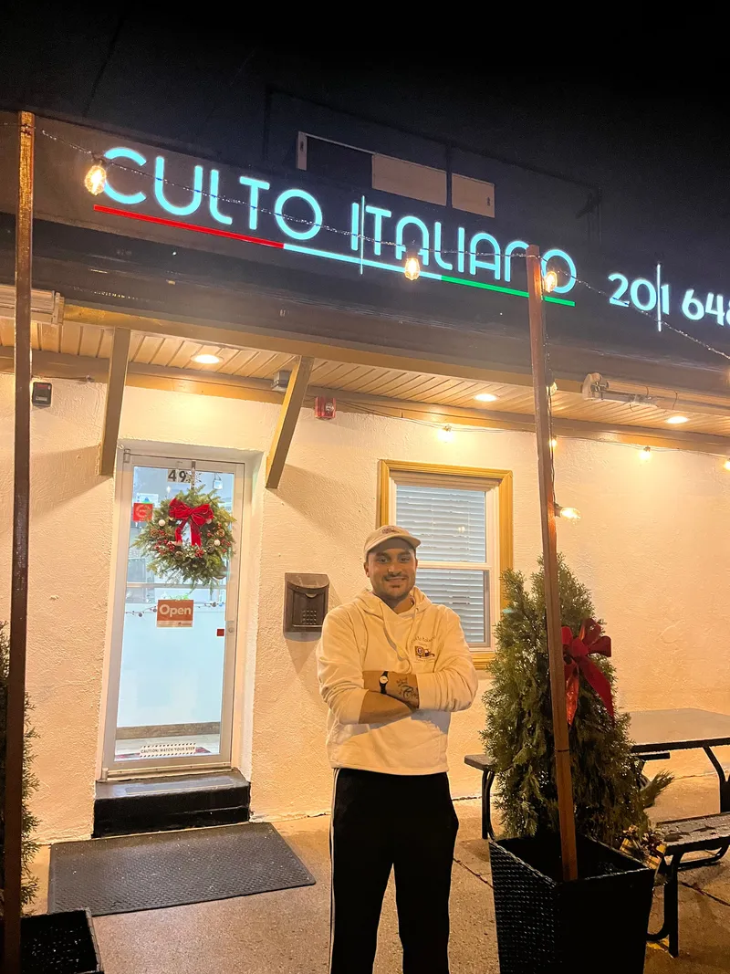 The Culto Italiano storefront in Bergenfield at night, dressed for the holidays
